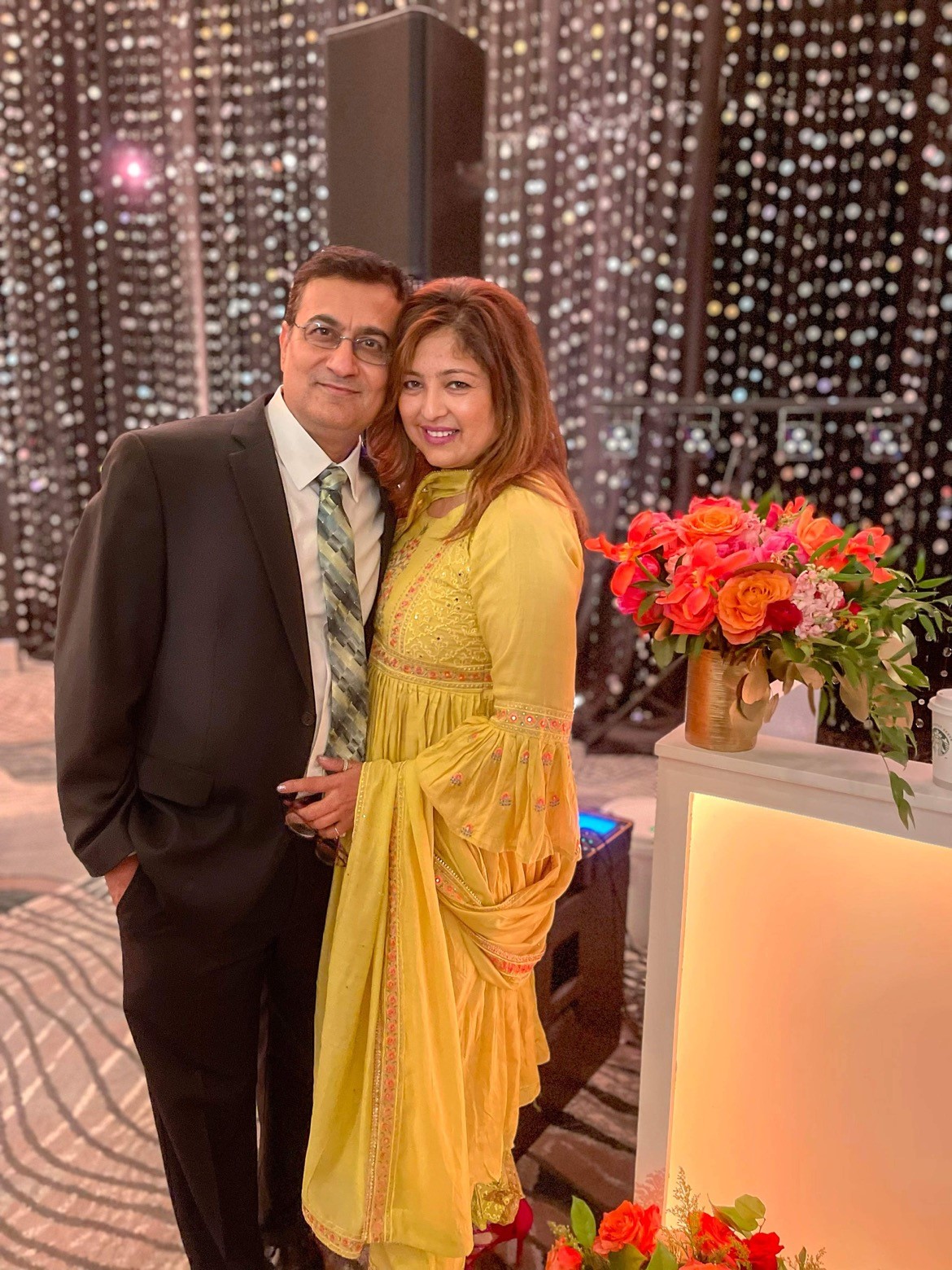 Mala B. and her husband, Dinesh, smile and pose together while wearing formal clothing at an event